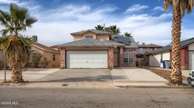 view of front of property featuring solar panels and a garage