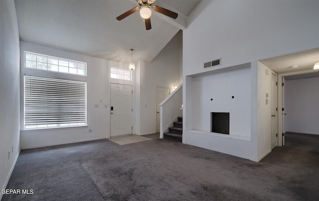 unfurnished living room with ceiling fan, high vaulted ceiling, and dark carpet