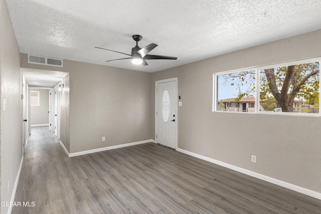 unfurnished room with ceiling fan, dark wood-type flooring, and a textured ceiling