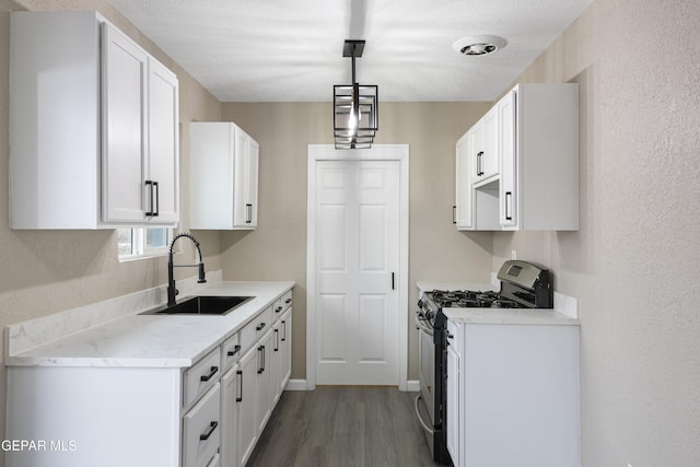 kitchen featuring sink, white cabinetry, white range with gas cooktop, hanging light fixtures, and dark wood-type flooring