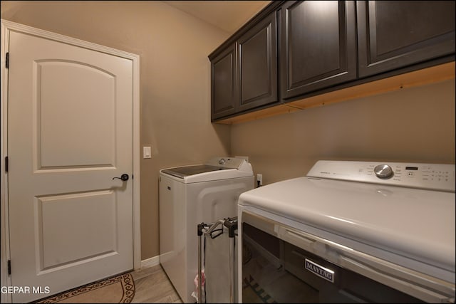 laundry room featuring separate washer and dryer, light tile patterned flooring, and cabinets