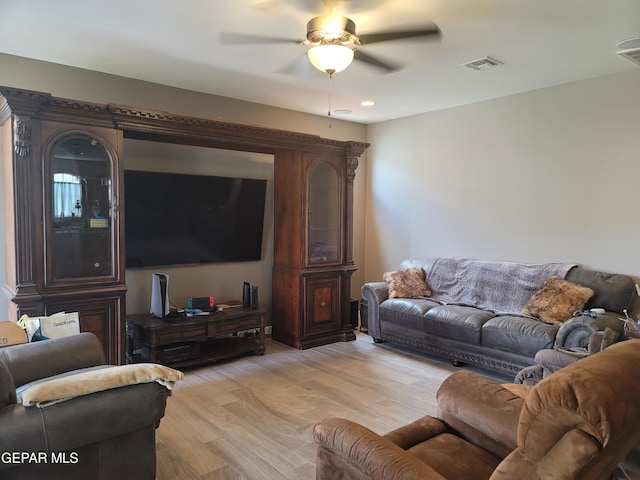 living room featuring ceiling fan and light hardwood / wood-style flooring