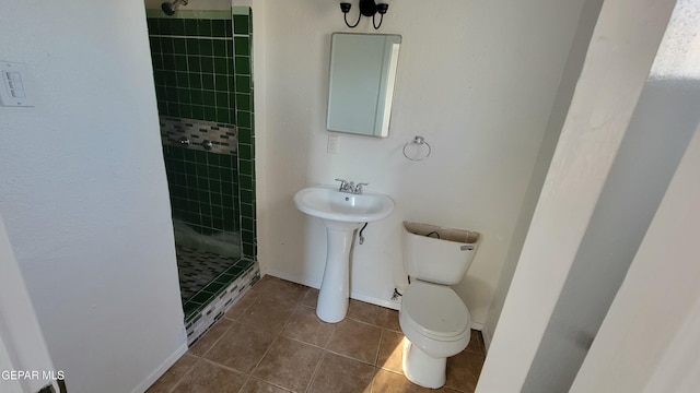 bathroom featuring a tile shower, tile patterned flooring, and toilet