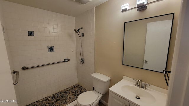 bathroom with vanity, a tile shower, and toilet