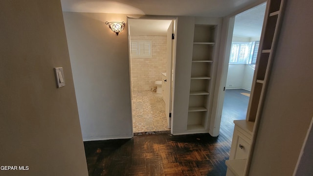 bathroom featuring parquet floors and built in shelves