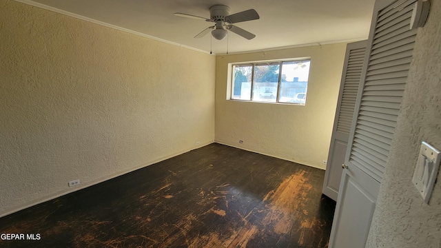 interior space featuring ornamental molding, dark wood-type flooring, and ceiling fan