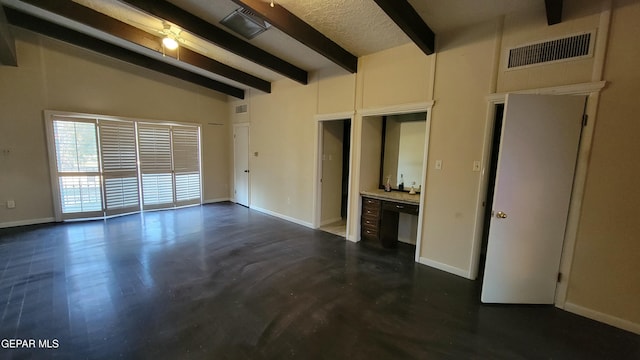 unfurnished room featuring beam ceiling