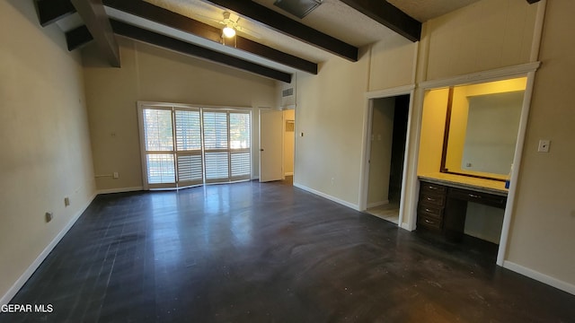 unfurnished room featuring vaulted ceiling with beams, built in desk, and ceiling fan