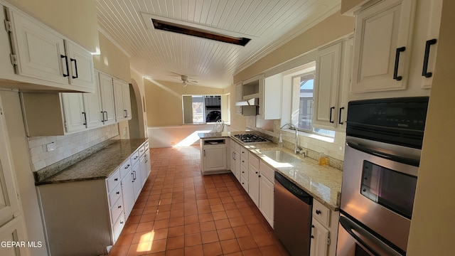 kitchen featuring sink, light tile patterned floors, white cabinetry, stainless steel appliances, and tasteful backsplash