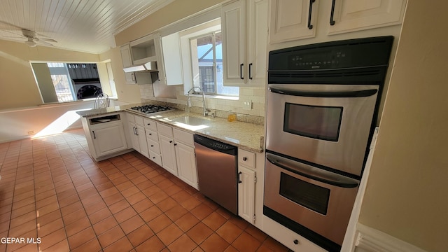 kitchen with appliances with stainless steel finishes, a wealth of natural light, sink, white cabinets, and decorative backsplash