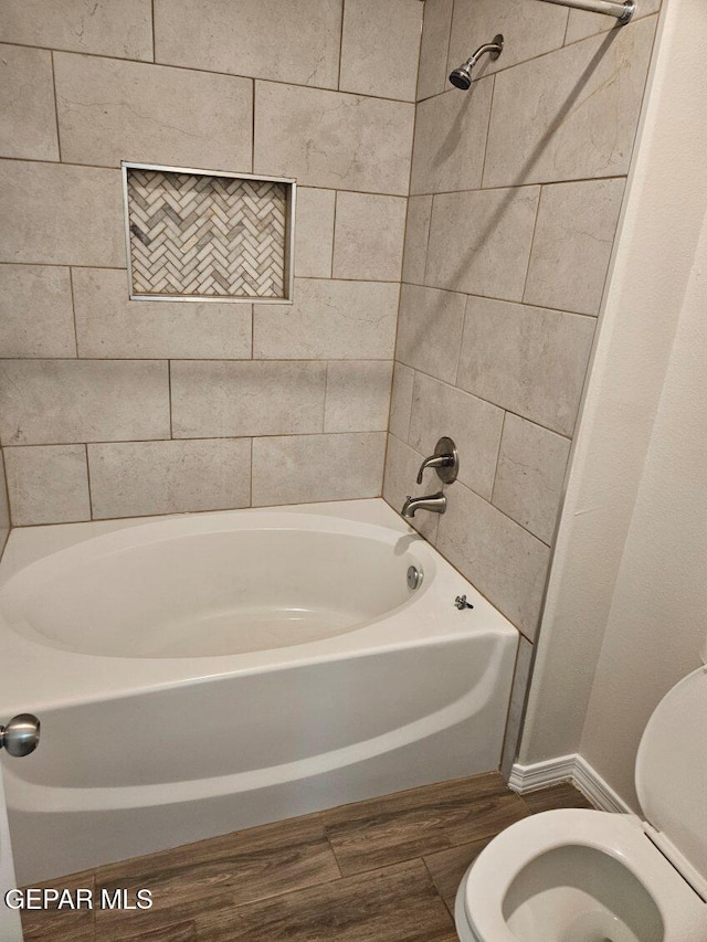 bathroom with tiled shower / bath and toilet