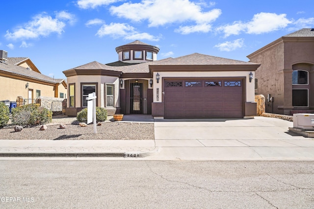 prairie-style home featuring a garage, driveway, and stucco siding