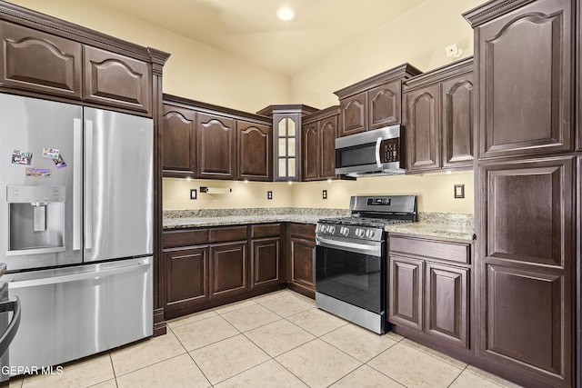 kitchen with light tile patterned floors, light stone countertops, recessed lighting, dark brown cabinetry, and appliances with stainless steel finishes