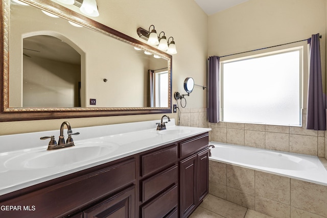 bathroom featuring tile patterned floors, a bath, double vanity, and a sink