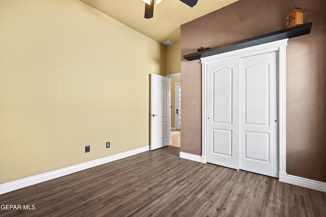 unfurnished bedroom featuring a closet, ceiling fan, baseboards, and dark wood-style flooring