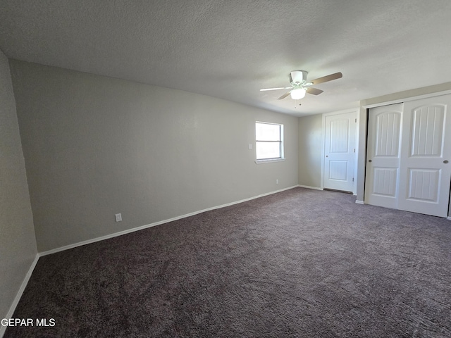 unfurnished bedroom with dark colored carpet, a textured ceiling, and ceiling fan