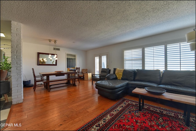 living room featuring wood-type flooring and a textured ceiling