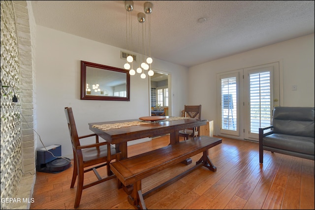 dining room with a textured ceiling and hardwood / wood-style floors