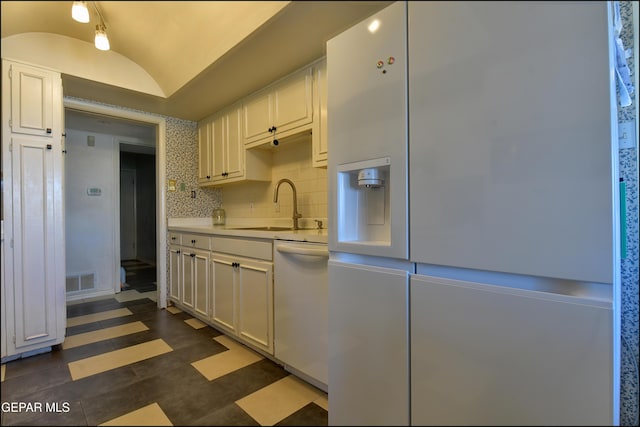 kitchen featuring lofted ceiling, white appliances, and white cabinets