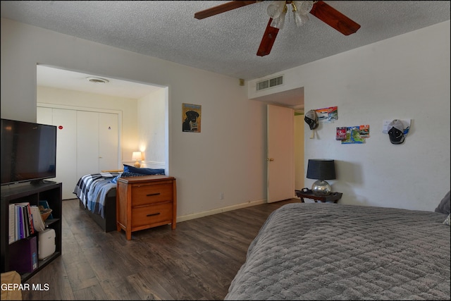 bedroom featuring dark hardwood / wood-style flooring, a closet, ceiling fan, and a textured ceiling