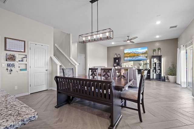 dining space with ceiling fan with notable chandelier and light parquet floors