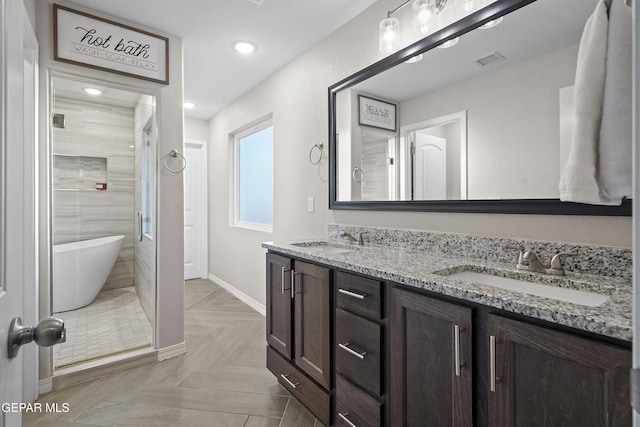 bathroom featuring parquet floors, a bathtub, and vanity