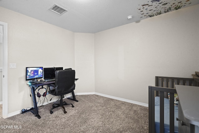 carpeted office featuring a textured ceiling