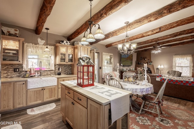 kitchen featuring pendant lighting, beam ceiling, a kitchen island, and backsplash