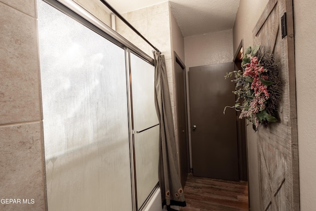 hallway with hardwood / wood-style floors and a textured ceiling