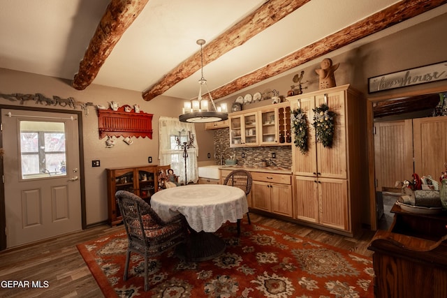 dining room featuring dark hardwood / wood-style flooring, beamed ceiling, and an inviting chandelier