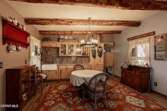 dining area with dark hardwood / wood-style floors, a chandelier, and beam ceiling