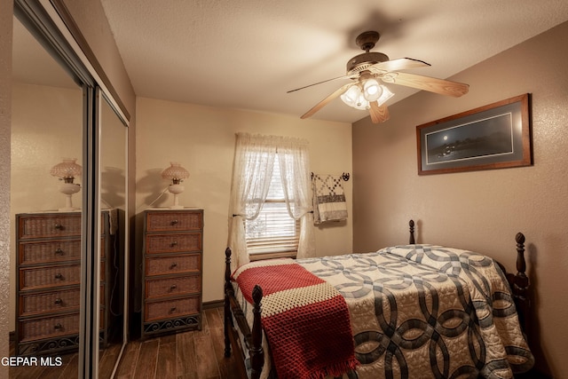 bedroom with dark hardwood / wood-style flooring, a textured ceiling, ceiling fan, and a closet