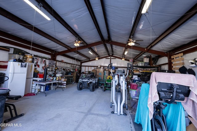 garage with a workshop area, ceiling fan, and white refrigerator