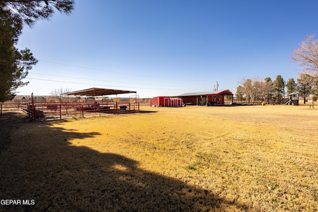 view of yard featuring a rural view and an outbuilding