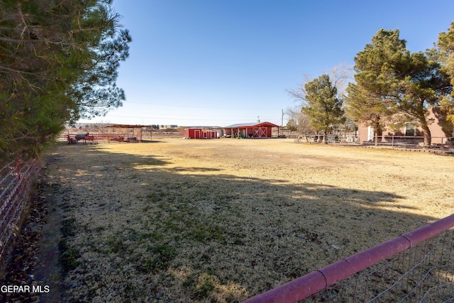 view of yard with a rural view and an outdoor structure