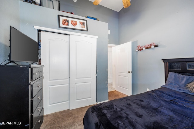 carpeted bedroom featuring ceiling fan and a closet