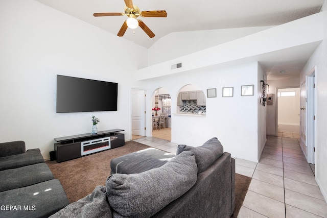 living room with ceiling fan, light tile patterned floors, and lofted ceiling