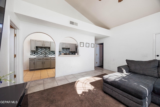 tiled living room with high vaulted ceiling and sink