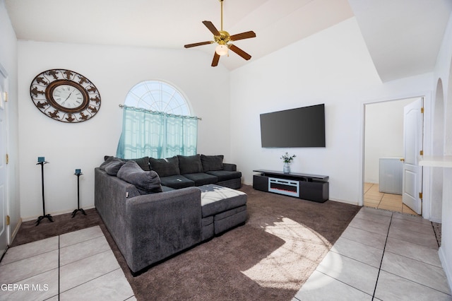 living room with ceiling fan, light tile patterned floors, and lofted ceiling