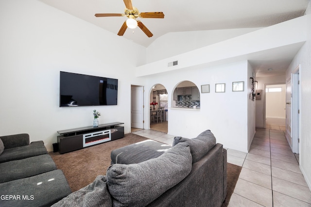 living room featuring light tile patterned floors, vaulted ceiling, and ceiling fan