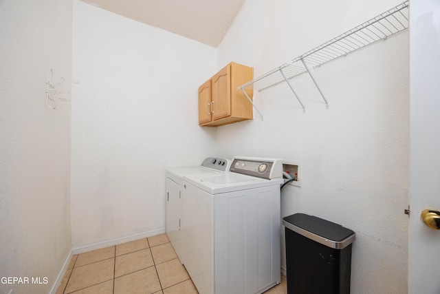 laundry area featuring washer and dryer, cabinets, and light tile patterned floors