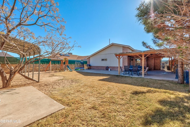 view of yard featuring a playground and a patio