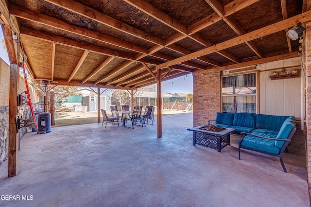 view of patio / terrace featuring a storage unit and an outdoor living space with a fire pit