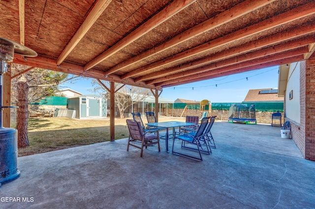 view of patio with a trampoline and a shed