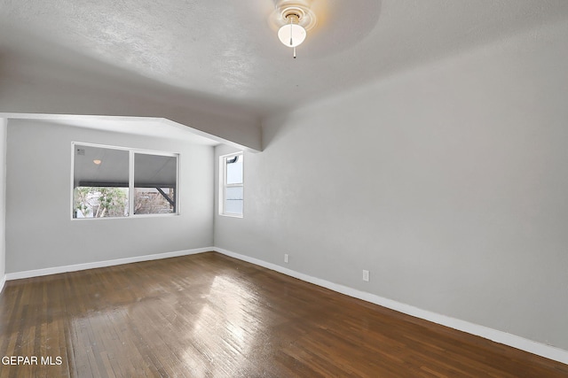 spare room featuring ceiling fan and dark wood-type flooring