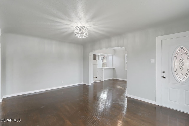 foyer entrance featuring a chandelier and dark hardwood / wood-style floors