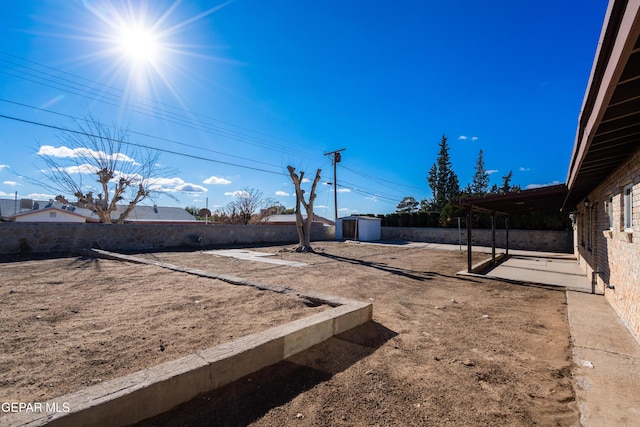 view of yard featuring a storage shed and a patio