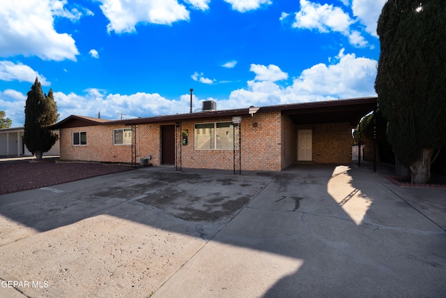 view of front of house featuring central air condition unit and a carport