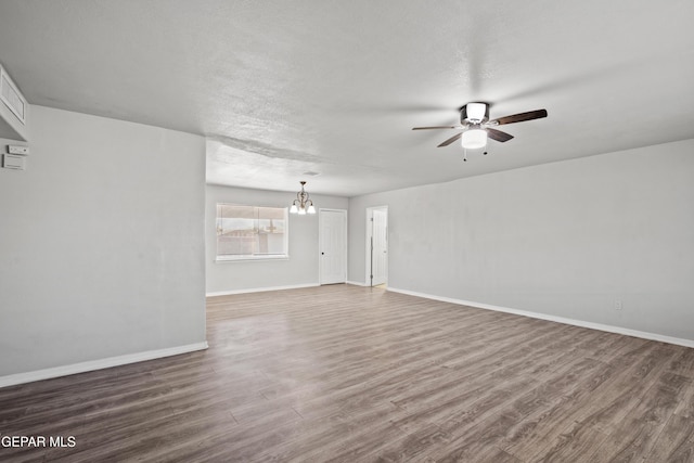 interior space featuring a textured ceiling, ceiling fan with notable chandelier, and dark hardwood / wood-style floors