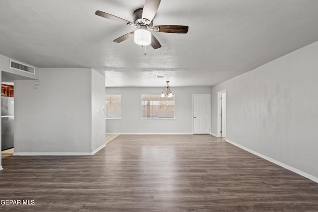 unfurnished living room featuring ceiling fan with notable chandelier and dark wood-type flooring